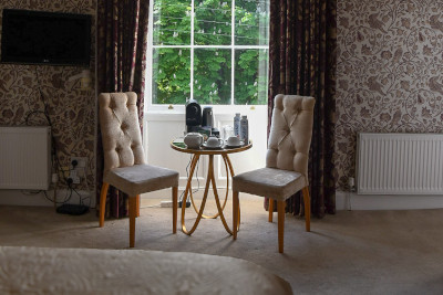 chairs at a bedroom window with coffee and tea